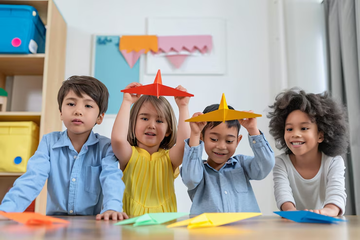 Two children holding paper planes in classroom